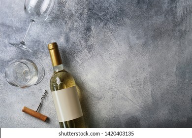 Unopened Vintage Bottle Of White Wine With Blank Label, Empty Wineglass & Bunches Of Different Grapes On Wooden Table Background. Expensive Bottle Of Chardonnay Concept. Copy Space, Top View, Flat Lay