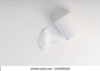 Unpacked Roll Of Toilet Paper On A White Table, Top View. The Concept Of Cleanliness And Softness