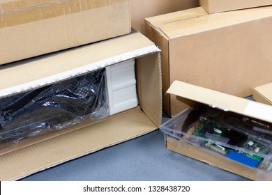 Unpacking Black Personal Computer, Back View, Cellophane Packaging. Many Boxes For Desktop Hardware Parts.