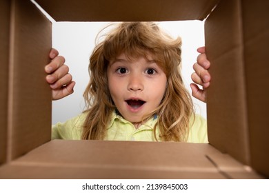 Unpacking cardboard box for kids. Happy little child boy is opening gift and looking inside cardboard box. - Powered by Shutterstock