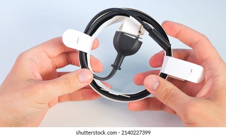 Unpacking A New Black Power Cable On White Table , Top View. Overhead View Of Man On White Office Table Background Unboxing Power Cable.