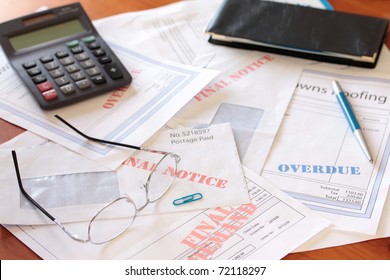 Unpaid Bills On Table With Calculator