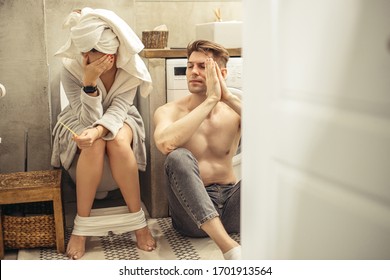 Unplanned Pregnancy Of Young Caucasian Couple, Man And Woman Found Out Pregnancy In Toilet, Desperate Young Woman Is Crying About Her Unwanted Pregnancy, While Her Boyfriend Sit On The Floor