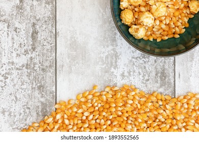 
Unpopped corn kernals shot against a light wooden background with space for text, copyspace.  National Popcorn Day 19 January 2021