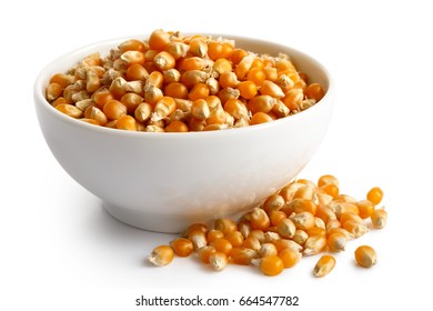 Unpopped popcorn
 in white ceramic bowl isolated on white. Spilled popcorn.