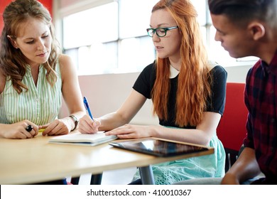 Unposed Group Of Creative Business People In An Open Concept Office Brainstorming Their Next Project.