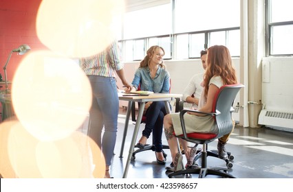 Unposed Group Of Creative Business People In An Open Concept Office Brainstorming Their Next Project.