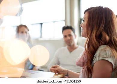 Unposed Group Of Creative Business People In An Open Concept Office Brainstorming Their Next Project.