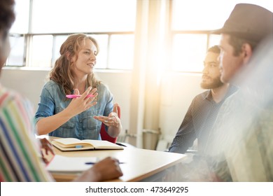 Unposed Group Of Creative Business People In An Open Concept Office Brainstorming Their Next Project.