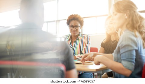 Unposed Group Of Creative Business People In An Open Concept Office Brainstorming Their Next Project.