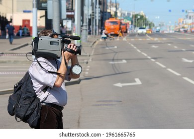 Unrecognisable camera operator stands on the street filming something. Copy space for your text. The Media theme.