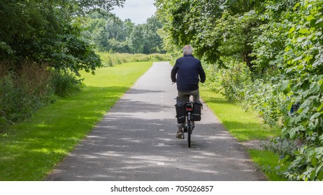 Unrecognisable Old Man Riding A Bike On Asphalt Road