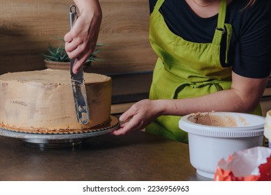 Unrecognisable woman decorating a delicious layered sponge cake with chocolate icing cream. DIY, sequence, step by step, part of series. - Powered by Shutterstock