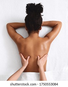 Unrecognizable african american woman having back massage, white background, top view