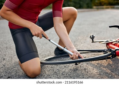 Unrecognizable Athlete Man Repairs Bicycle On Road Path, Outdoor. Hand Of Cyclist Bicyclist Examines, Fixes Modern Cycle Transmission System. Bike Maintenance, Cropped Guy In T-shirt And Shorts