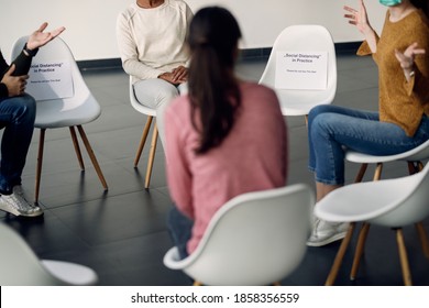 Unrecognizable Attenders Of Group Therapy Talking While Sitting On Safe Distance Due To COVID-19 Pandemic.