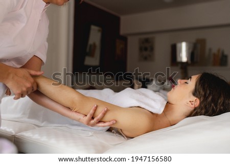 Unrecognizable beautician massaging arms in a beauty healthy center.