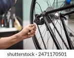 Unrecognizable bicycle mechanic assembling the braking and shifting system of a bike as part of the maintenance service he performs in his shop. Real people at work.