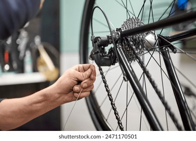 Unrecognizable bicycle mechanic assembling the braking and shifting system of a bike as part of the maintenance service he performs in his shop. Real people at work. - Powered by Shutterstock