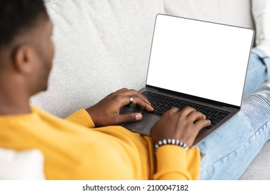 Unrecognizable Black Guy Using Modern Laptop With Empty Screen, Typing On Computer Keyboard, Reclining On Couch, Using Nice Software, Programming, Chatting With Ladies, Cropped, Mockup