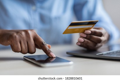 Unrecognizable Black Lady Browsing Mobile Banking App On Smartphone And Holding Credit Card, Paying Bills In Internet, Shopping Online, Transferring Money, Cropped Image, Closeup Shot