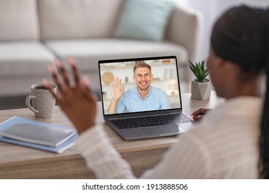 Unrecognizable Black Woman Having Video Chat With Young Man On Laptop While Staying Home, Back View, Copy Space. African American Lady Having Job Interview Online, Waving At Pc Screen