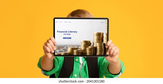 Unrecognizable Boy Holding Tablet Pc With Financial Literacy For Kids Website In Front Of His Face On Orange Studio Background, Banner Design. Online Economic Education For Children, Money Management