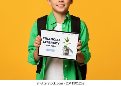 Unrecognizable Boy Showing Tablet Pc With Financial Literacy For Kids Website, Advertising Online Economic Education For Children, Orange Studio Background. Creative Collage