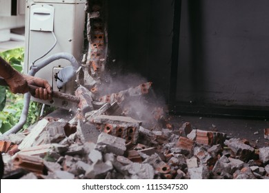 Unrecognizable Builder Using A Sledgehammer Breaking And Smashing The Wall Fallen Into Debris - Breaking Wall And Challenges Concept