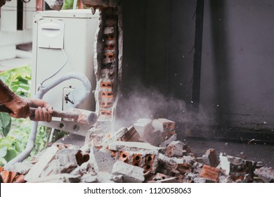 Unrecognizable Builder Using A Sledgehammer Breaking And Smashing The Wall Fallen Into Debris - Breaking Wall And Challenges Concept