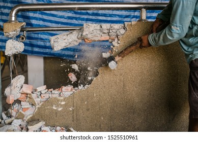 Unrecognizable Builder Using A Sledgehammer Breaking And Smashing The Wall Fallen Into Debris - Breaking Wall And Challenges Concept