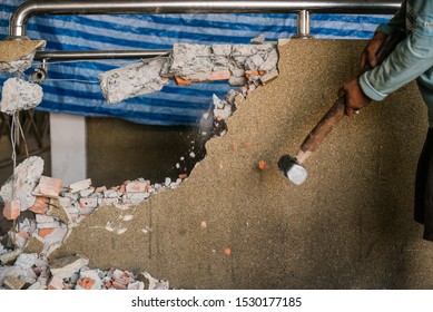 Unrecognizable Builder Using A Sledgehammer Breaking And Smashing The Wall Fallen Into Debris - Breaking Wall And Challenges Concept