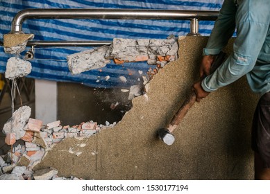 Unrecognizable Builder Using A Sledgehammer Breaking And Smashing The Wall Fallen Into Debris - Breaking Wall And Challenges Concept