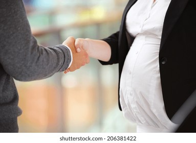 Unrecognizable businessman and businesswomen having a meeting in shopping mall. Woman is pregnant. - Powered by Shutterstock