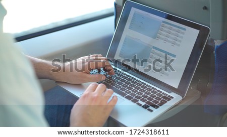 Unrecognizable businessman studying graphs and stats while riding a train. Concept of business lifestyle