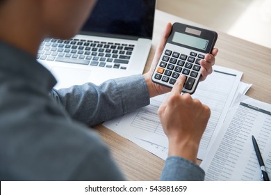 Unrecognizable businessman using calculator - Shutterstock ID 543881659
