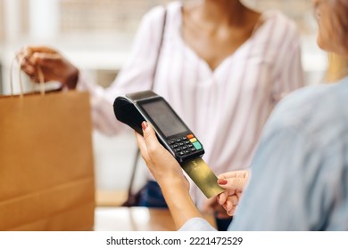 Unrecognizable Ceramic Store Owner Swiping A Credit Card On A Card Reader To Receive A Payment. Female Small Business Owner Doing A Cashless Transaction While Serving A Customer At Checkout.