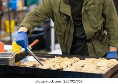 An unrecognizable chef cooking dumplings on the streets of Asia - Powered by Shutterstock