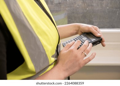 Unrecognizable civil engineer using a calculator in a construction site, wears yellow high visibility vest, ppe, personal protective equipment, indoors - Powered by Shutterstock