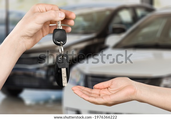 An\
unrecognizable client receiving keys of rent\
car