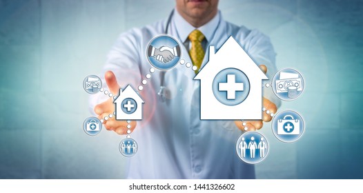 Unrecognizable Clinician Presenting A Deal Between A Small Hospital And A Larger Health Care Provider Organization. Concept For Healthcare Mergers And Acquisitions, Economy Of Scale, Consolidation.