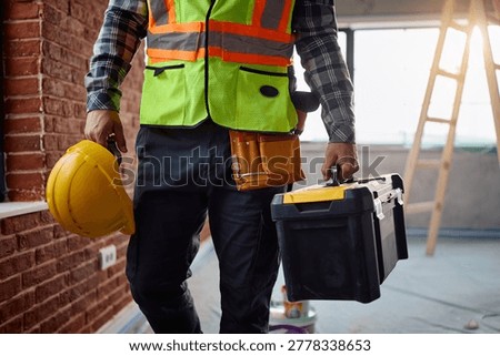 Unrecognizable construction site worker with a toolbox at renovating home. 