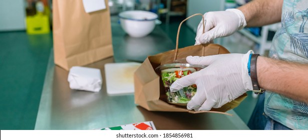 Unrecognizable cook packing a takeaway food order in the kitchen
