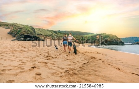 Unrecognizable couple with a fat bike taking a walk on the beach with their dog