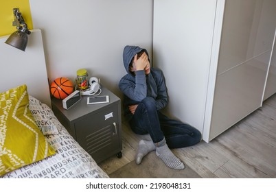 Unrecognizable Depressed Male Teenager With His Hand On His Head Sitting On The Floor In His Bedroom