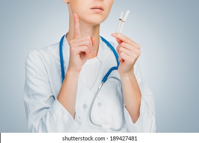 Unrecognizable doctor holds broken cigarettes, smoking cessation - Powered by Shutterstock