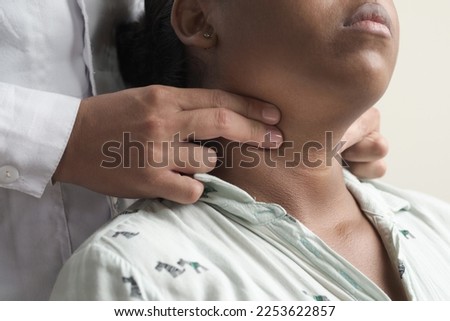 unrecognizable doctor's hands palpating carotid pulse female patient