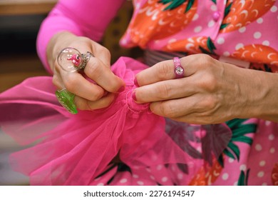 Unrecognizable dressmaker with colorfull clothes hand sewing a piece of fabric in a sewing workshop. - Shutterstock ID 2276194547
