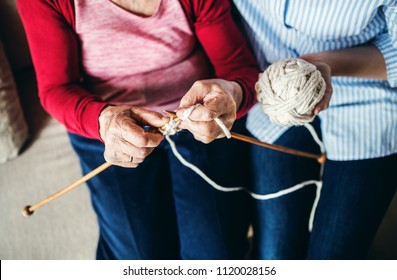 An unrecognizable elderly grandmother and adult granddaughter at home, knitting. - Powered by Shutterstock