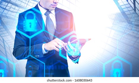 Unrecognizable engineer working with tablet computer in city with double exposure of blurry cyber security interface. Concept of data protection. Toned image